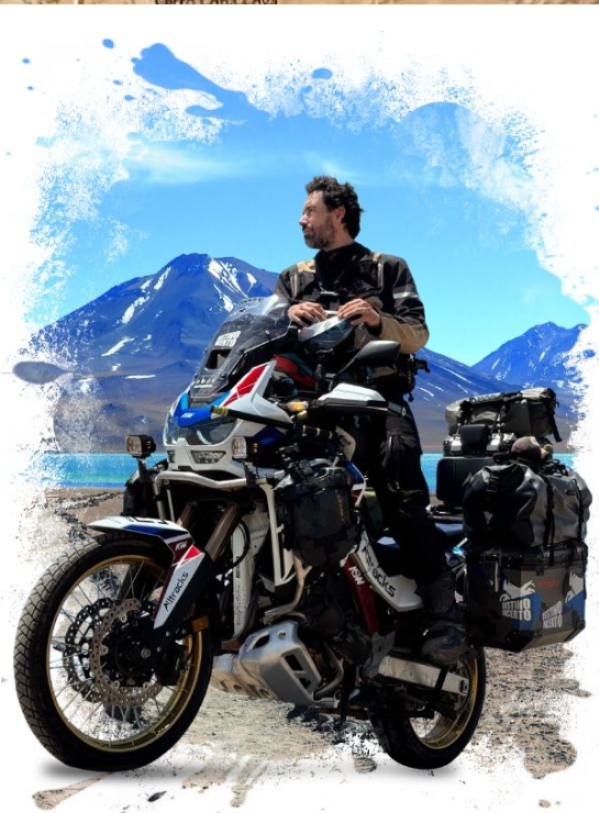 Ton com moto de aventura em paisagem de laguna e montanhas.
